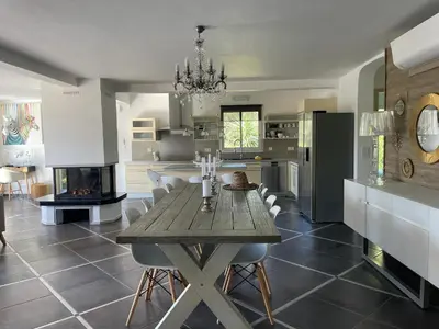 a kitchen with a wooden table and a dining room at Villa CASA BAGGIA, proche plage, piscine à débordement chauffée, pool house in Porto-Vecchio