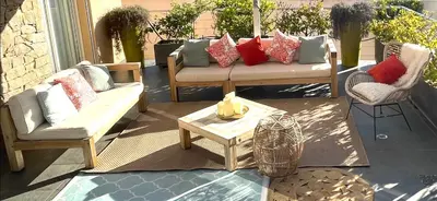 a patio with two chairs and a couch and a table at Villa CASA BAGGIA, proche plage, piscine à débordement chauffée, pool house in Porto-Vecchio