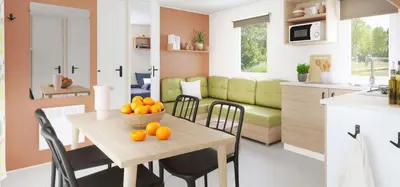 a kitchen and living room with a table with oranges on it at Camping Porto Vecchio in Porto-Vecchio