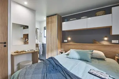 a bedroom with a large bed and a desk at Camping Porto Vecchio in Porto-Vecchio