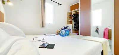 a hospital bed with a cell phone and a bag on it at Camping Porto Vecchio in Porto-Vecchio