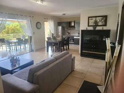 a living room with a couch and a tv and a kitchen at Christelle in Propriano