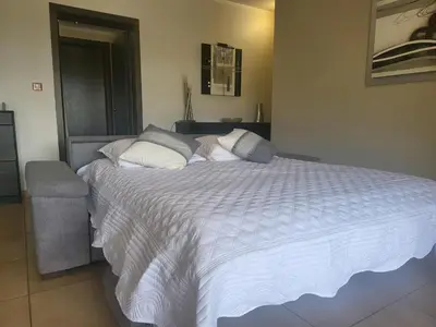 a bedroom with a large bed with a white comforter at Christelle in Propriano