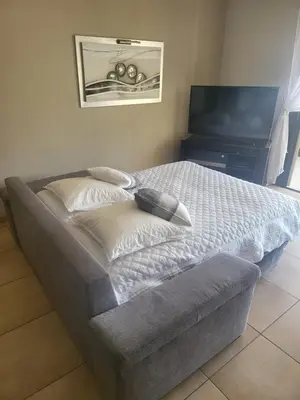 a bed in a room with a tv and a bedskirtspectspectspectspects at Christelle in Propriano