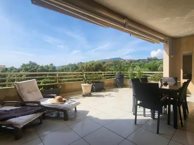 a dog laying on a chair on a patio at Christelle in Propriano