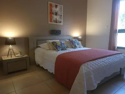 a bedroom with a bed and a table with a lamp at Christelle in Propriano