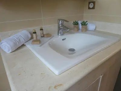 a bathroom sink with a roll of toilet paper on it at Christelle in Propriano