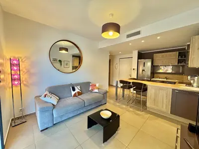 a living room with a couch and a kitchen at Rena Bianca tout confort proche plage et centre ville in Propriano