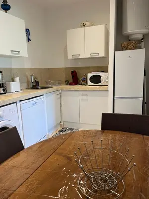 a kitchen with a wooden table and white appliances at Tradition Corse & Modernité Ì Caseddi dì Barabè Appartement A Cantina in Granace