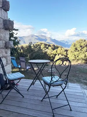 a table and chairs sitting on a deck with a view at Tradition Corse & Modernité Ì Caseddi dì Barabè Appartement A Cantina in Granace