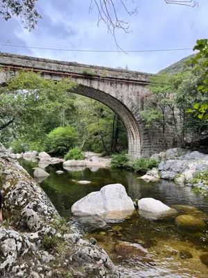 an old stone bridge over a river with rocks at Tradition Corse & Modernité Ì Caseddi dì Barabè Appartement A Cantina in Granace