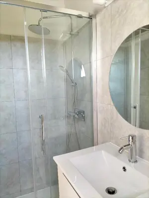 a bathroom with a shower with a sink and a mirror at Studio vue mer à Porticcio proche aéroport Ajaccio in Porticcio