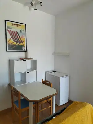 a dining room with a table and a refrigerator at Studio vue mer à Porticcio proche aéroport Ajaccio in Porticcio