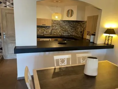 a kitchen with a wooden table and a counter top at Appartement Cemiliana in Bonifacio