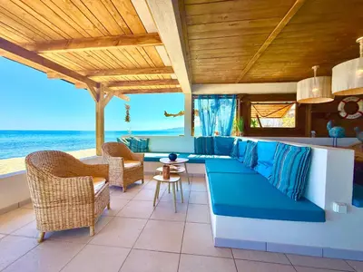 a living room with a couch and chairs and the ocean at Casamarina2a Maisons bord de mer in Ghisonaccia