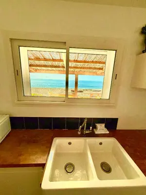 a bathroom with a sink and a window with a beach at Casamarina2a Maisons bord de mer in Ghisonaccia