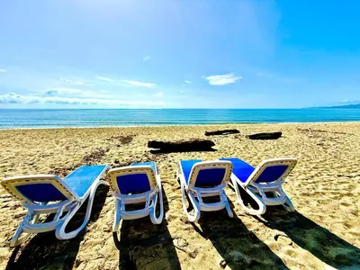 two lawn chairs sitting in the sand on a beach at Casamarina2a Maisons bord de mer in Ghisonaccia