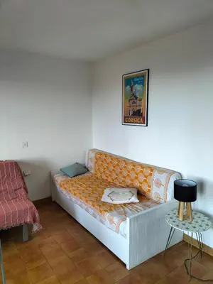 an orange couch in a room with a table at T2 vue mer à Porticcio, proche aéroport Ajaccio in Porticcio