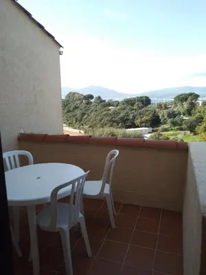 a white table and chairs on a balcony with a view at T2 vue mer à Porticcio, proche aéroport Ajaccio in Porticcio