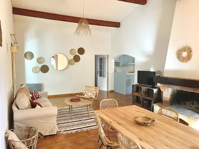 a living room with a table and a fireplace at Villa privée dans un cadre verdoyant , piscine et grand jardin in Porto-Vecchio