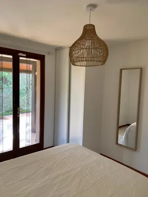 a bedroom with a bed and a mirror at Villa privée dans un cadre verdoyant , piscine et grand jardin in Porto-Vecchio
