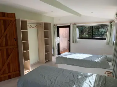 a bedroom with two beds and a window at Villa privée dans un cadre verdoyant , piscine et grand jardin in Porto-Vecchio