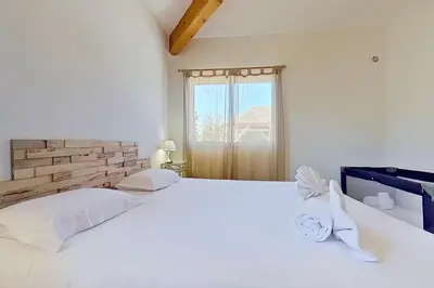 a white bedroom with two beds and a window at CALA CORSICA - Villas 5 Etoiles T5 Piscine privée - Villa T4 Piscine privée chauffée - Villa T3 Piscine partagée - Internet Fibre - Entièrement Climatisée à Lecci de Porto-Vecchio Cala Rossa in Lecci