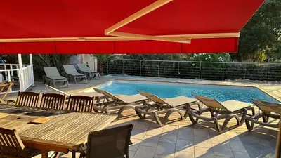 a patio with a table and chairs on a deck at CALA CORSICA - Villas 5 Etoiles T5 Piscine privée - Villa T4 Piscine privée chauffée - Villa T3 Piscine partagée - Internet Fibre - Entièrement Climatisée à Lecci de Porto-Vecchio Cala Rossa in Lecci