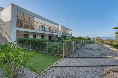 a building with a fence in front of it at Le Luciani in Coti-Chiavari