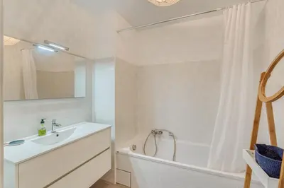 a white bathroom with a sink and a bath tub at Le Luciani in Coti-Chiavari