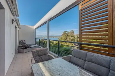 a balcony with a table and chairs and a large window at Le Luciani in Coti-Chiavari