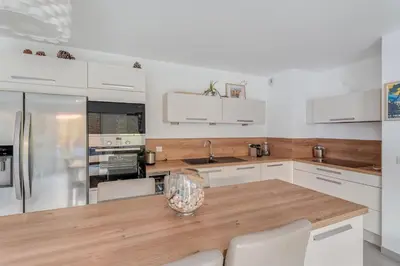a kitchen with white cabinets and a wooden counter top at Le Luciani in Coti-Chiavari