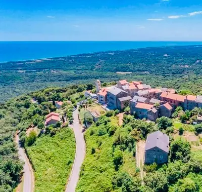 an aerial view of a house on a hill near the ocean at Villa Poggio in Santa-Maria-Poggio