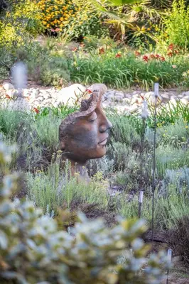a statue of a head in the grass at Domain U Tempu Persu Sleeps 12 with Park in Porticcio
