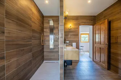 a bathroom with wood paneled walls and a sink at Domain U Tempu Persu Sleeps 12 with Park in Porticcio