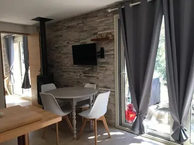 a living room with a table and chairs and a brick wall at Petite maison en pierre in Saint-Florent