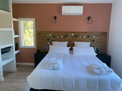 a bedroom with a large white bed with two pillows at Villa Ghjuvan - Sea, Mountain & Spa in Peri