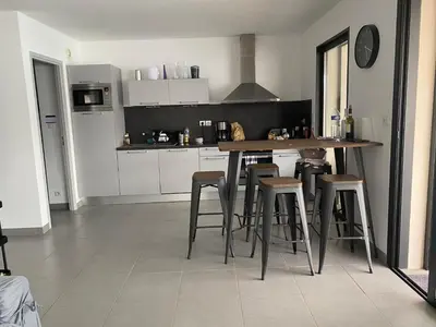 a kitchen with a table and some bar stools at Appartement les pieds dans l'eau 3 Chambres - Propriano - Corse in Propriano