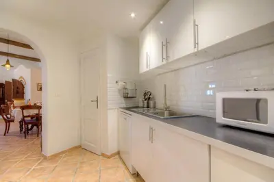 a white kitchen with a sink and a microwave at Le Campu Latinu in Lama