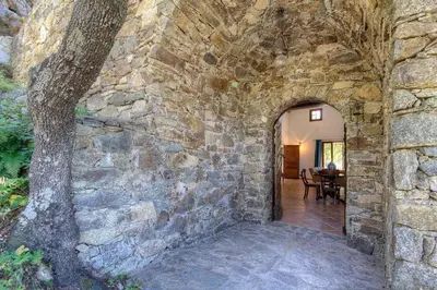 an entrance to a stone wall with a tree at Le Campu Latinu in Lama