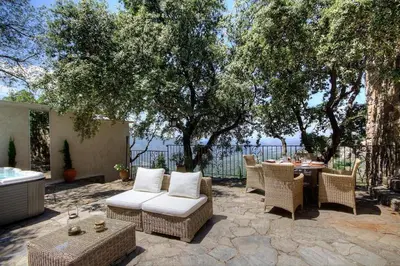 a patio with a table and chairs and trees at Le Campu Latinu in Lama