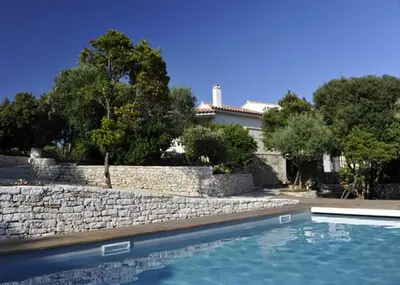 a house with a stone wall and a swimming pool at Casa Martini in Bonifacio