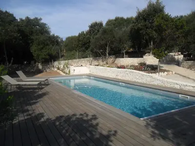 a swimming pool with a deck and a chair next to it at Casa Martini in Bonifacio