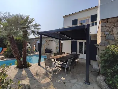 a patio with a table and chairs next to a house at Villa A CASA DI FICU à 14kms d'Ajaccio et des plages avec Piscine Jacuzzi Pétanque Sans vis à vis in Peri