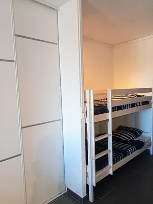 a room with two bunk beds and a closet at studio à 100m de la plage et de la piscine in Cervione