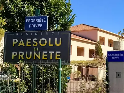 a sign on a fence in front of a house at studio à 100m de la plage et de la piscine in Cervione