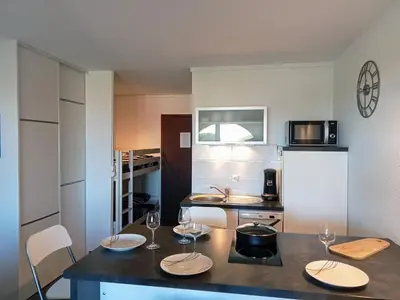 a kitchen with wine glasses on a counter at studio à 100m de la plage et de la piscine in Cervione