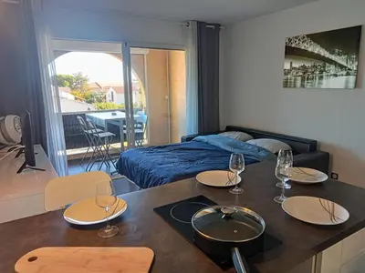 a room with a bed and a table with glasses on it at studio à 100m de la plage et de la piscine in Cervione