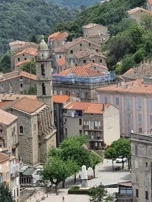 a city with a clock tower in a town at Charmant appartement en Rez de jardin in Sartène
