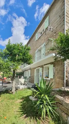 a building with a balcony on the side of it at Charmant appartement en Rez de jardin in Sartène